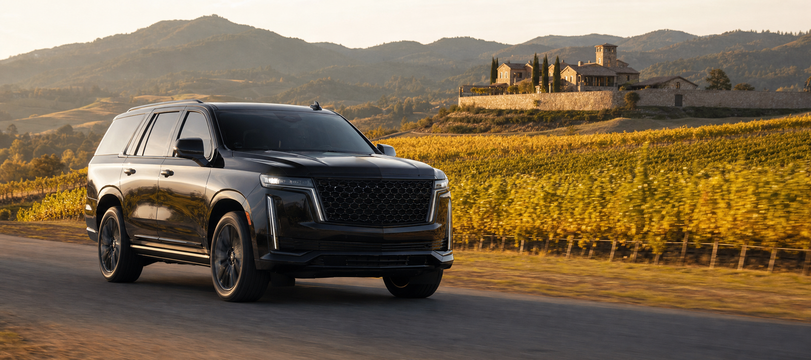 Black luxury Cadillac Escalade on a road beside a golden Napa Valley vineyard